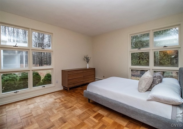 bedroom with light parquet floors and multiple windows