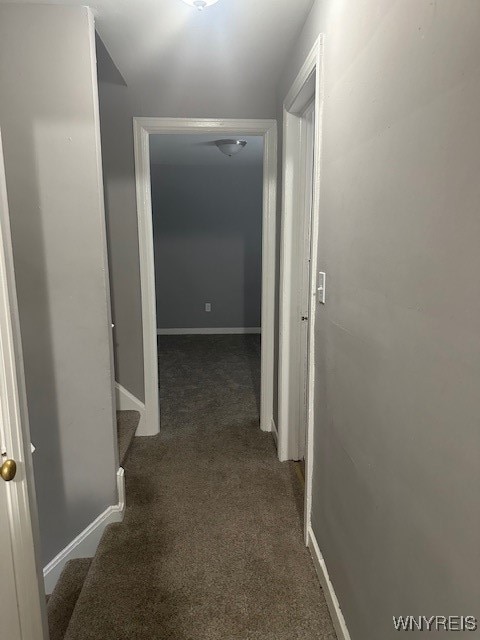 hallway with dark colored carpet