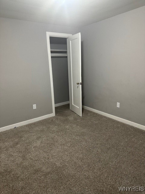 unfurnished bedroom featuring carpet and a closet