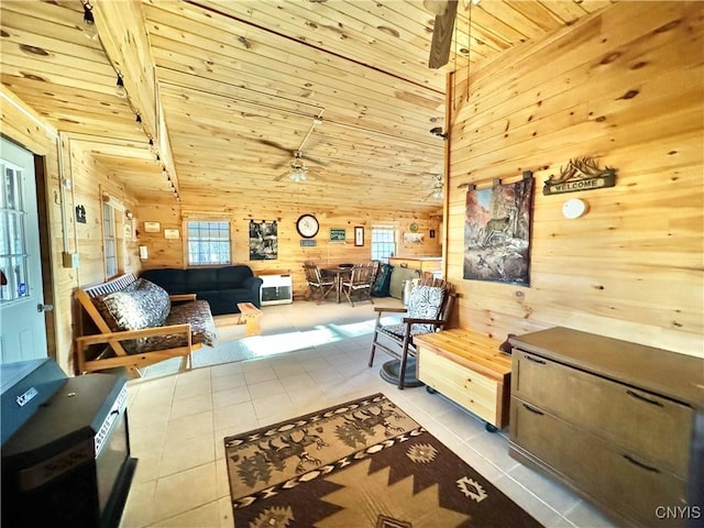 interior space with wooden walls, light tile patterned floors, wooden ceiling, and ceiling fan