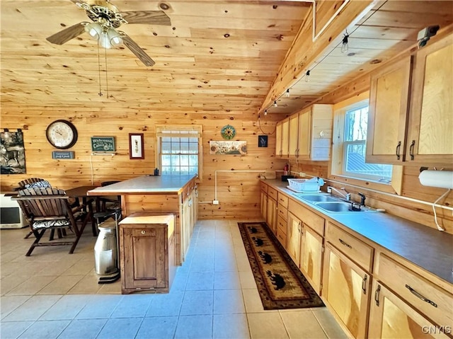 kitchen with a center island, wood walls, wooden ceiling, sink, and light brown cabinetry