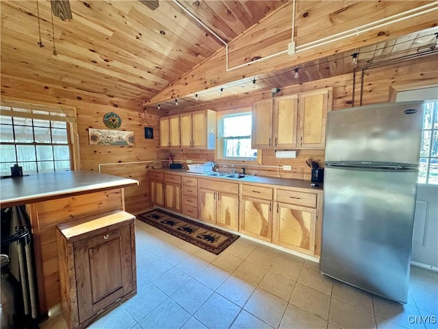 kitchen featuring stainless steel refrigerator, light brown cabinets, wooden ceiling, wood walls, and lofted ceiling