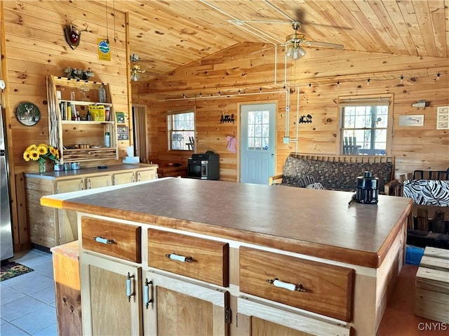 kitchen featuring a center island, wooden ceiling, light tile patterned floors, and vaulted ceiling