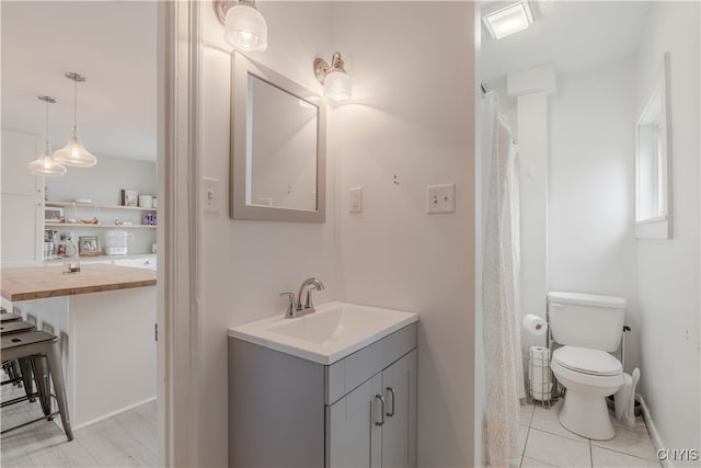 bathroom featuring tile patterned flooring, vanity, and toilet