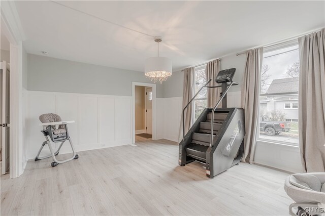 interior space with light hardwood / wood-style floors, a wealth of natural light, and a chandelier