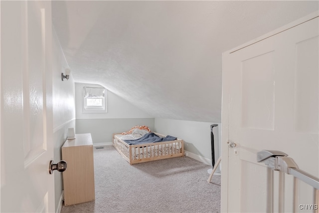 bedroom with carpet floors and vaulted ceiling