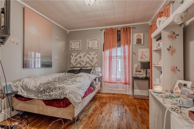 bedroom with wood-type flooring and ornamental molding