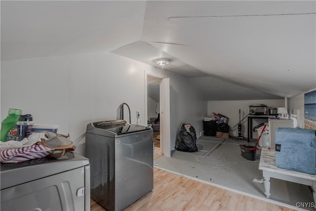 clothes washing area featuring light hardwood / wood-style floors and washer / dryer