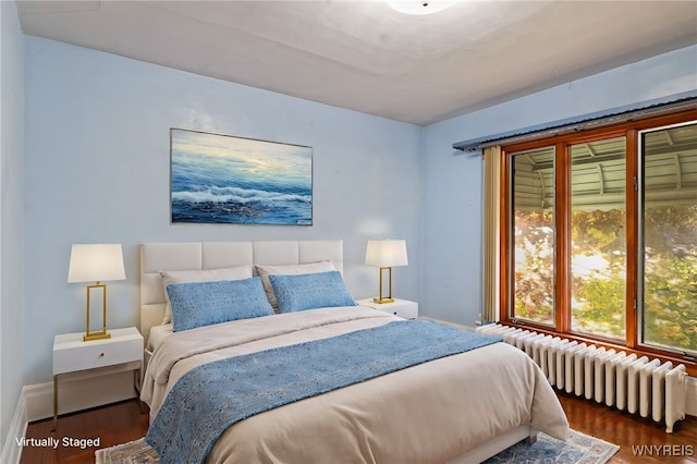 bedroom with radiator heating unit and dark hardwood / wood-style floors