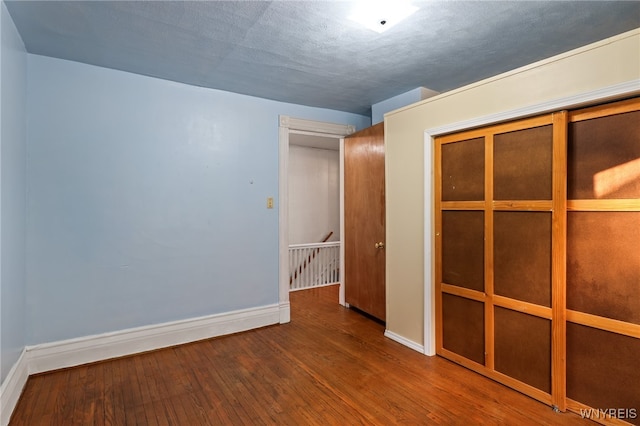 unfurnished room featuring hardwood / wood-style floors and a textured ceiling