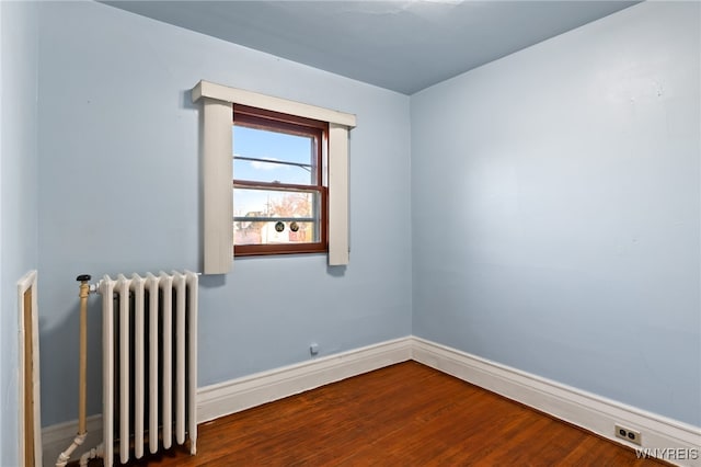 empty room featuring radiator heating unit and wood-type flooring