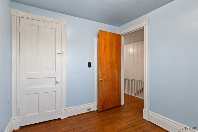 unfurnished bedroom with dark hardwood / wood-style flooring