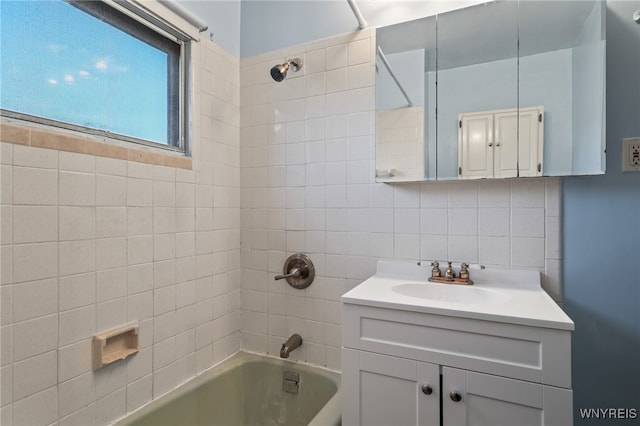 bathroom with backsplash, vanity, and tiled shower / bath