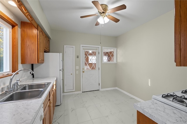 kitchen featuring white appliances, ceiling fan, and sink