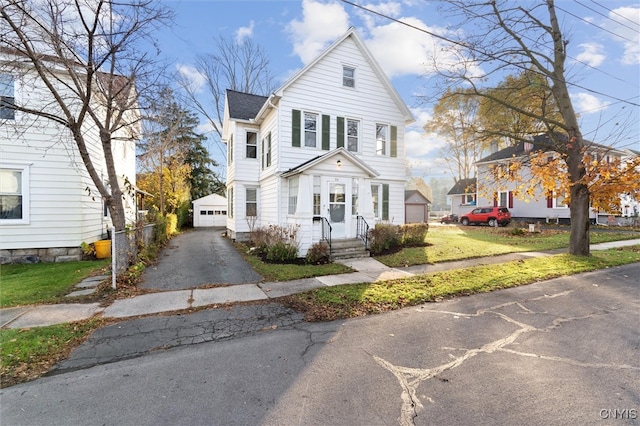 view of front property with an outbuilding, a garage, and a front lawn