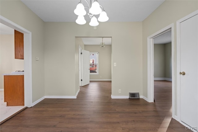 unfurnished dining area with a chandelier and dark wood-type flooring