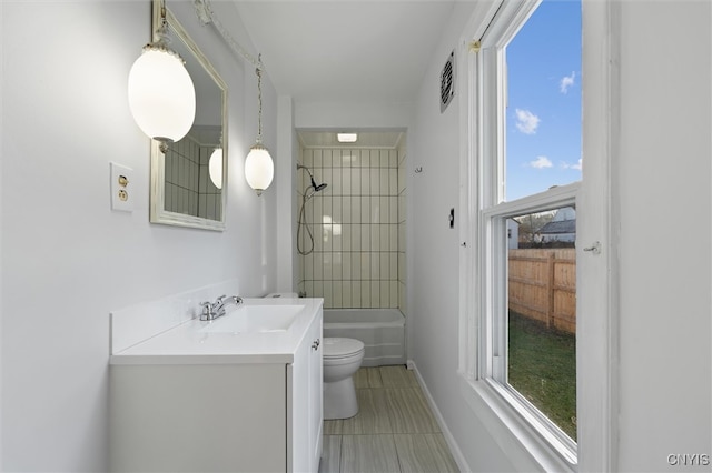 full bathroom featuring tile patterned floors, vanity, tiled shower / bath combo, and toilet