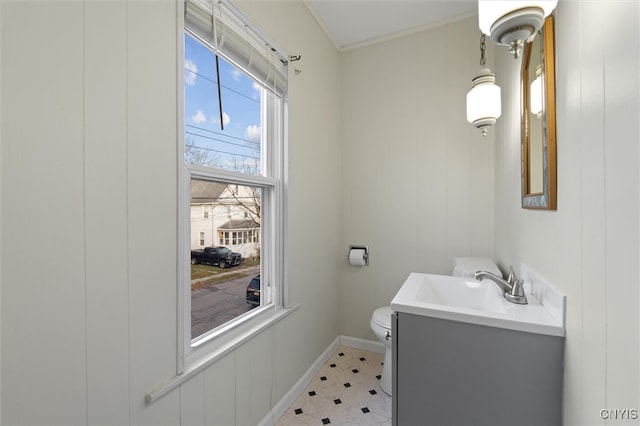 bathroom with vanity, toilet, ornamental molding, and wood walls