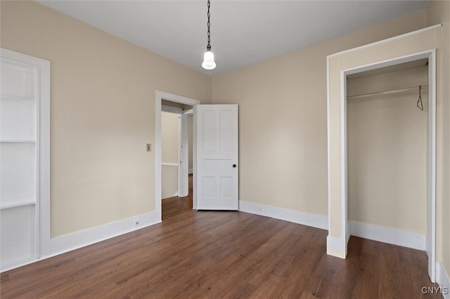 unfurnished bedroom featuring a closet and dark hardwood / wood-style flooring