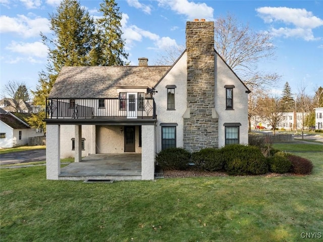 30 University Ave, Hamilton, NY 13346 - back of property featuring a chimney, a patio area, a yard, a balcony, and stucco siding
