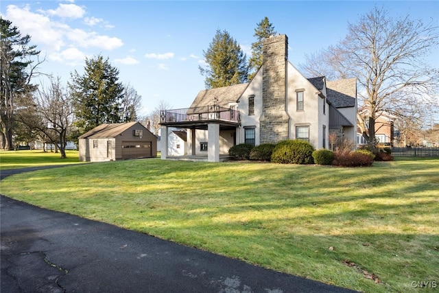 view of front of property featuring a garage, an outbuilding, and a front lawn