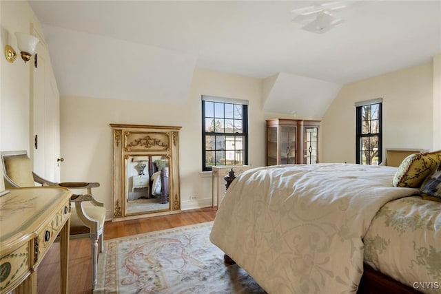 bedroom featuring light hardwood / wood-style floors and vaulted ceiling