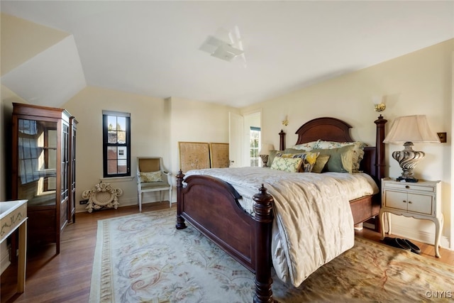 bedroom featuring wood-type flooring and vaulted ceiling