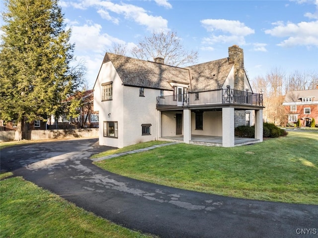 back of property featuring a patio area, a yard, and a wooden deck