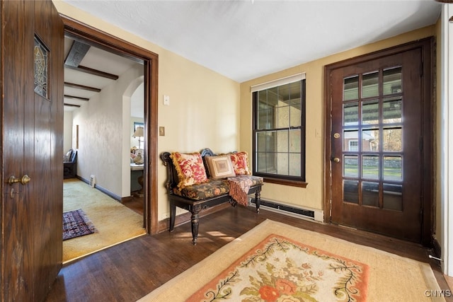 doorway with beam ceiling, light hardwood / wood-style flooring, and baseboard heating