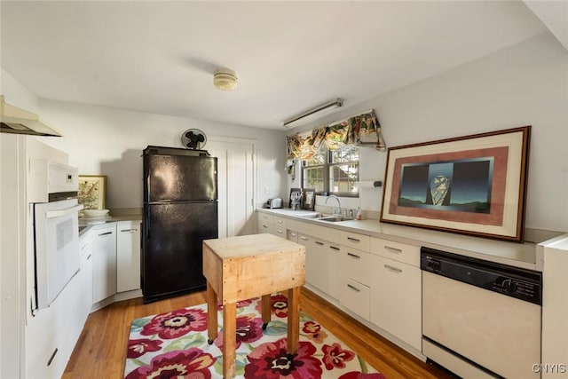 kitchen with white cabinets, white appliances, light hardwood / wood-style floors, and sink