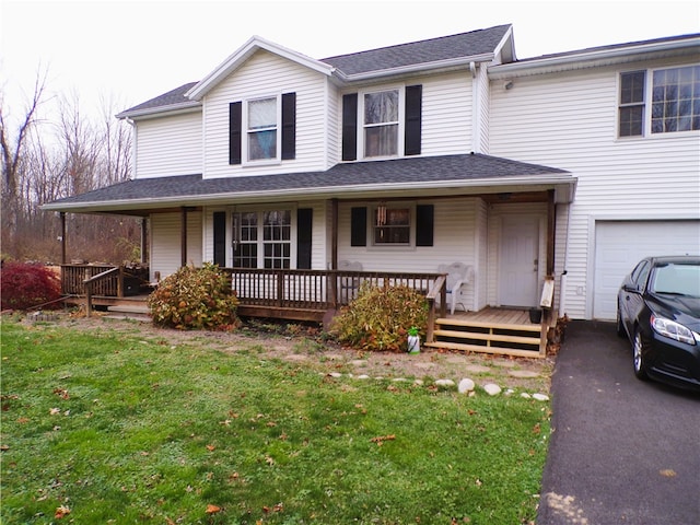 view of front of home featuring a porch, a garage, and a front lawn