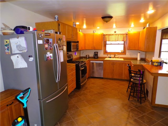 kitchen featuring a healthy amount of sunlight, sink, light tile patterned floors, and stainless steel appliances