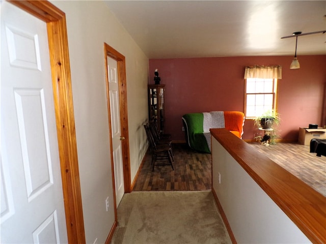 hall featuring dark colored carpet