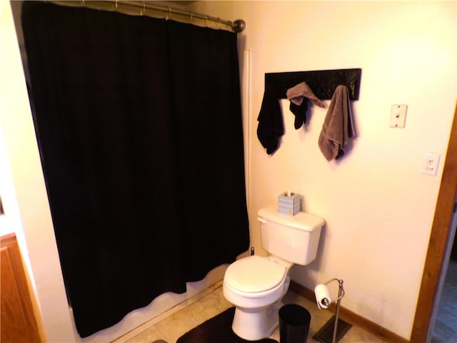 bathroom with tile patterned flooring, toilet, and curtained shower