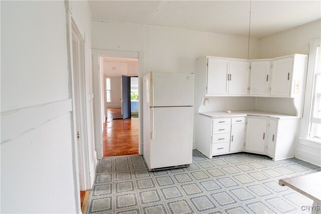 kitchen featuring light hardwood / wood-style floors, white fridge, and white cabinetry