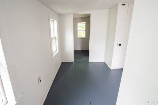 hallway featuring a textured ceiling and dark hardwood / wood-style floors