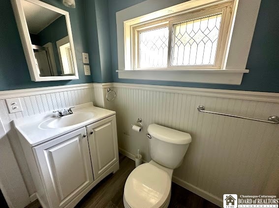 bathroom with toilet, vanity, and hardwood / wood-style flooring