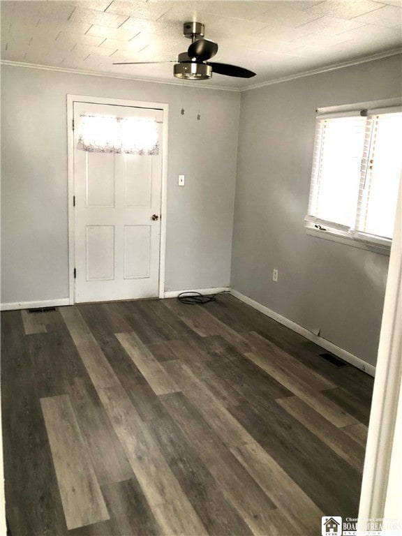 interior space featuring ceiling fan, ornamental molding, and dark wood-type flooring