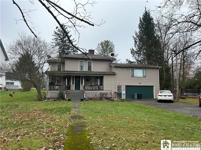 front of property with covered porch, a garage, and a front yard