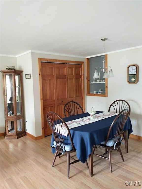 dining space featuring light hardwood / wood-style flooring and ornamental molding