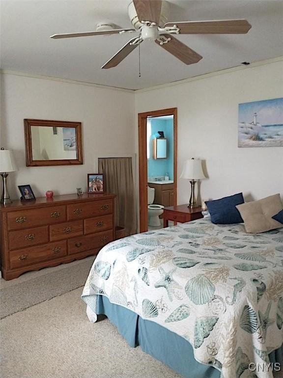 bedroom with ceiling fan, crown molding, and ensuite bath