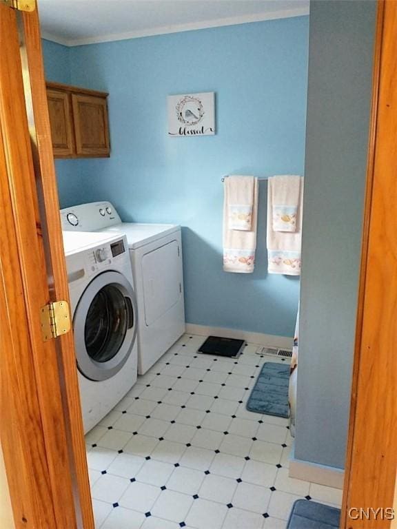 washroom with crown molding, cabinets, and washing machine and dryer