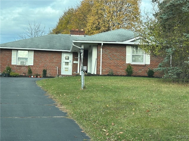 view of front of house with a front lawn and cooling unit