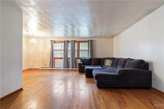 living room featuring an inviting chandelier, a baseboard radiator, and hardwood / wood-style flooring