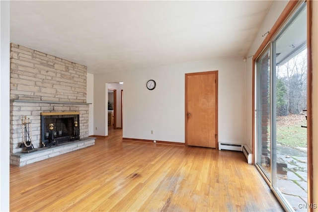 unfurnished living room with light hardwood / wood-style floors, a fireplace, and a baseboard radiator