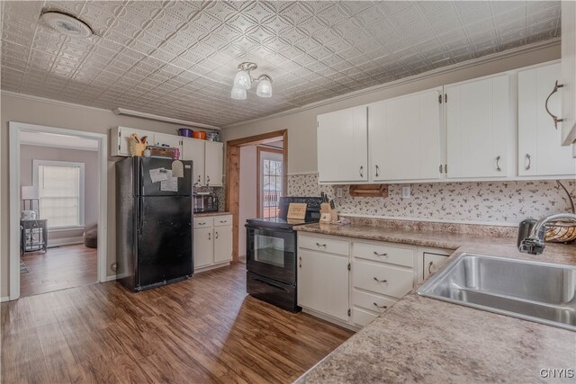 kitchen with sink, white cabinetry, a healthy amount of sunlight, and black appliances