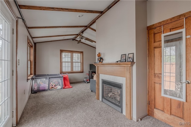 carpeted living room with a fireplace and vaulted ceiling with beams