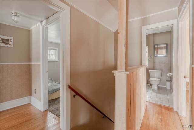 corridor featuring light wood-type flooring and crown molding