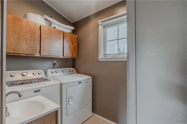 laundry area featuring cabinets, light tile patterned floors, washer and clothes dryer, and sink