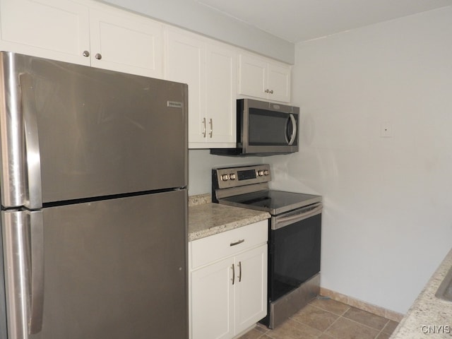 kitchen featuring appliances with stainless steel finishes, white cabinetry, and light tile patterned flooring